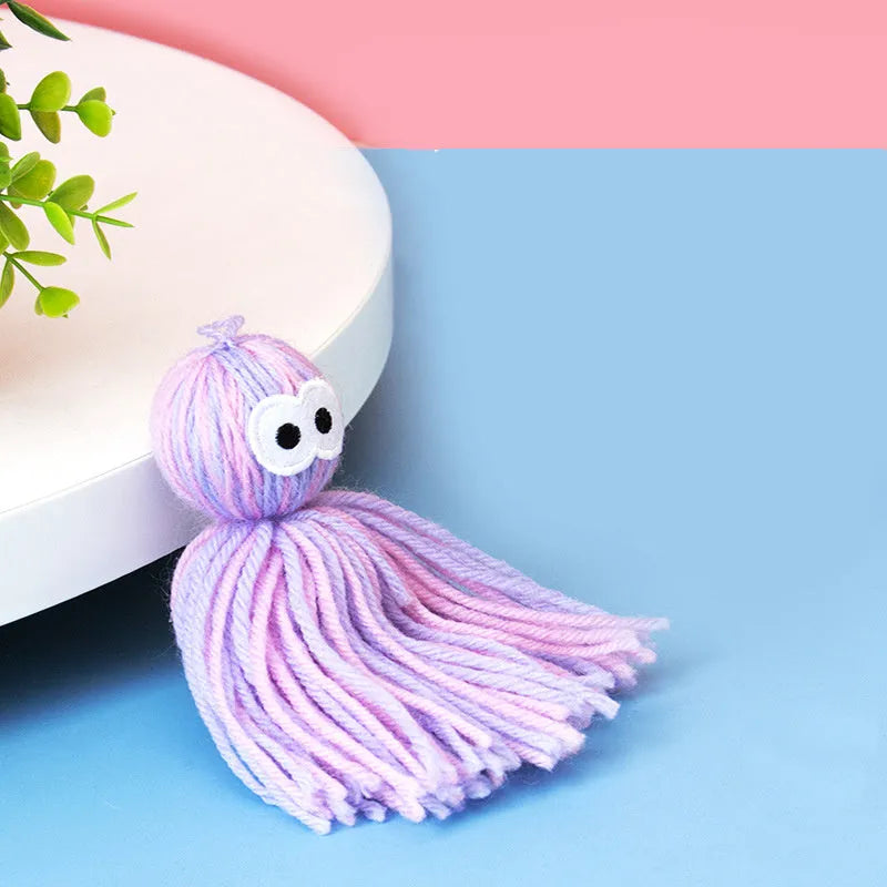 Blue and grey bite-resistant wool ball cat toy hanging from a teaser stick.