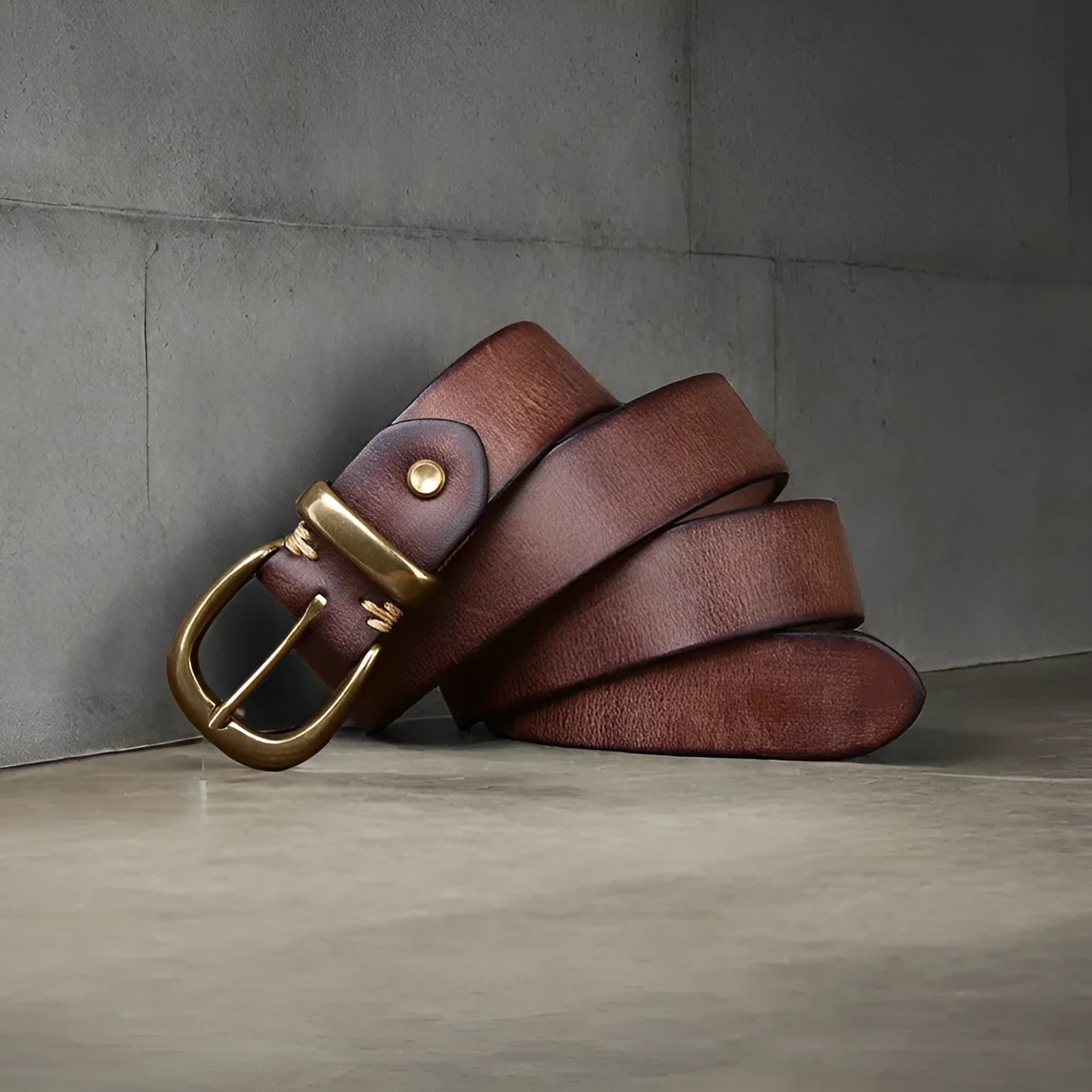 Men's black genuine cattlehide leather belt with a copper pin buckle on a jeans background