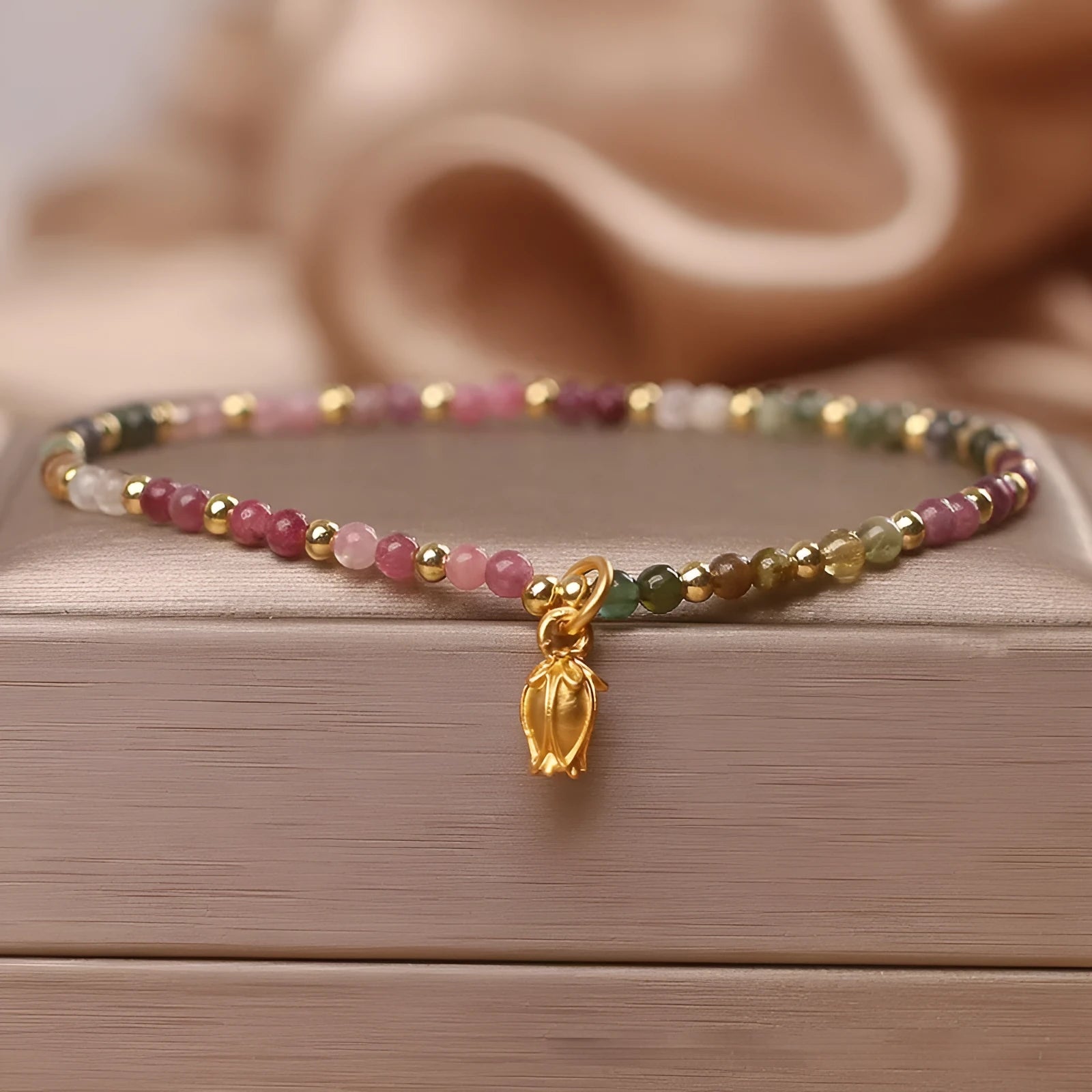 Natural tourmaline beaded floral anklet shown as adjustable bracelet on woman's wrist