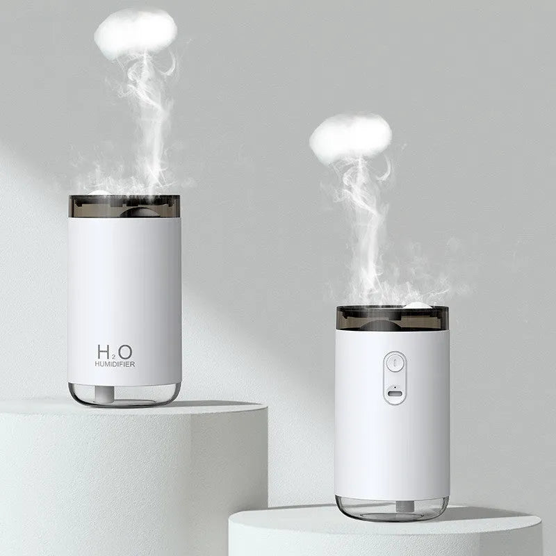 White portable USB humidifier emitting jellyfish-shaped smoke rings with a warm glowing night light on a desk