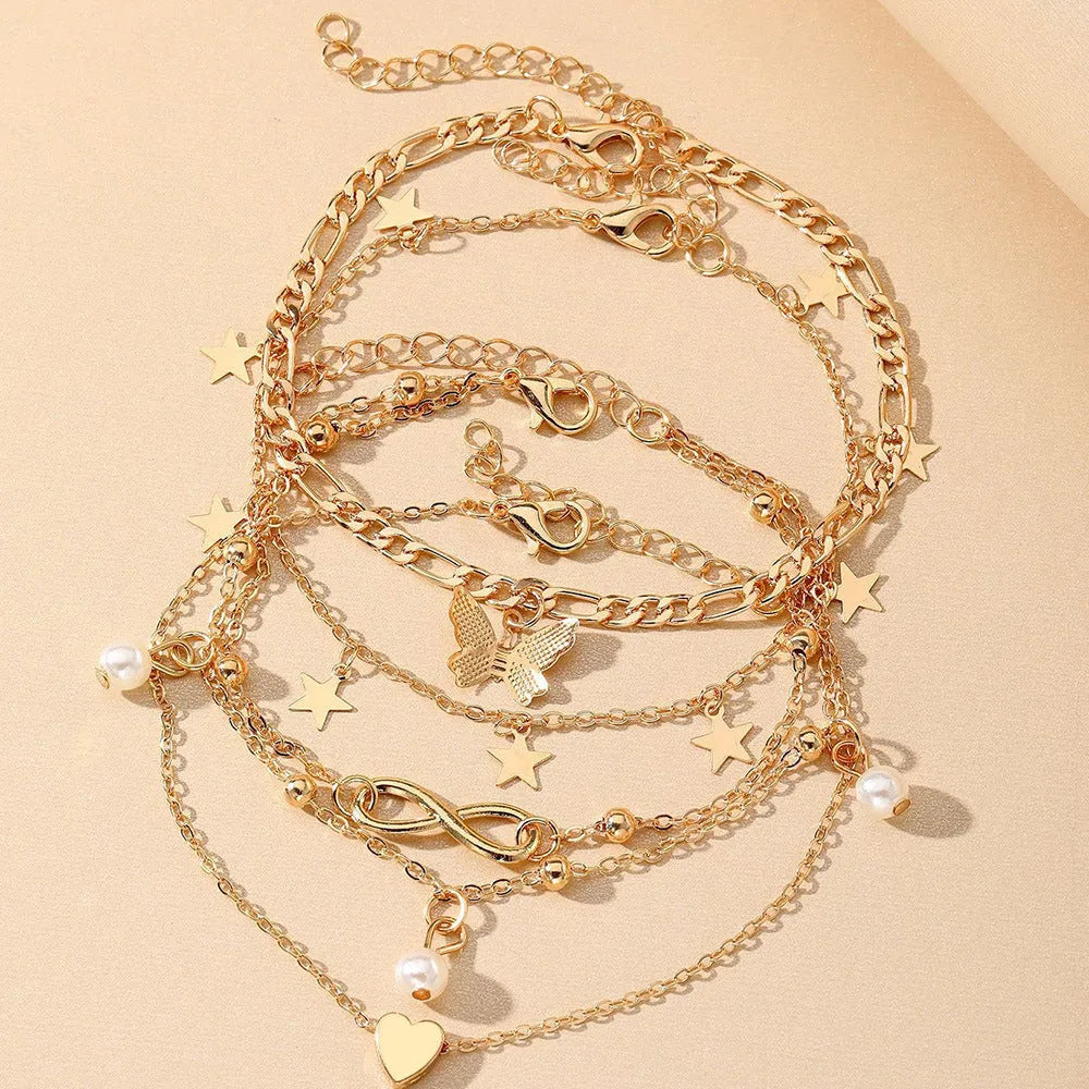 Four-piece women's alloy anklet set with butterfly and pearl heart charms in multi-layer design