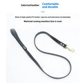 Black PU leather dog traction belt with metal chain ring on a wooden surface.
