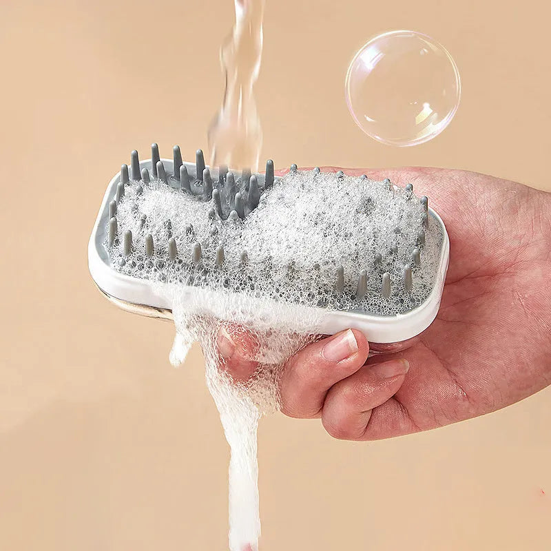 Grey and pink silicone pet bath brush for dogs and cats, handheld with soft bristles.