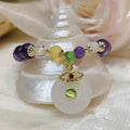 Purple crystal bracelet with ethnic money bag pendant and peace buckle closure on wrist