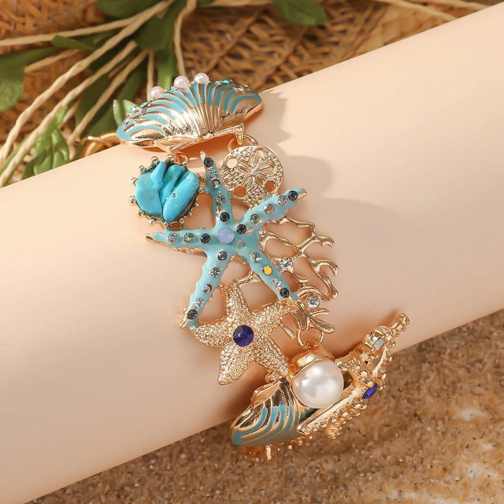 Alloy rhinestone bracelet with boat anchor, marine shell, and starfish charms in blue, red, or turquoise.