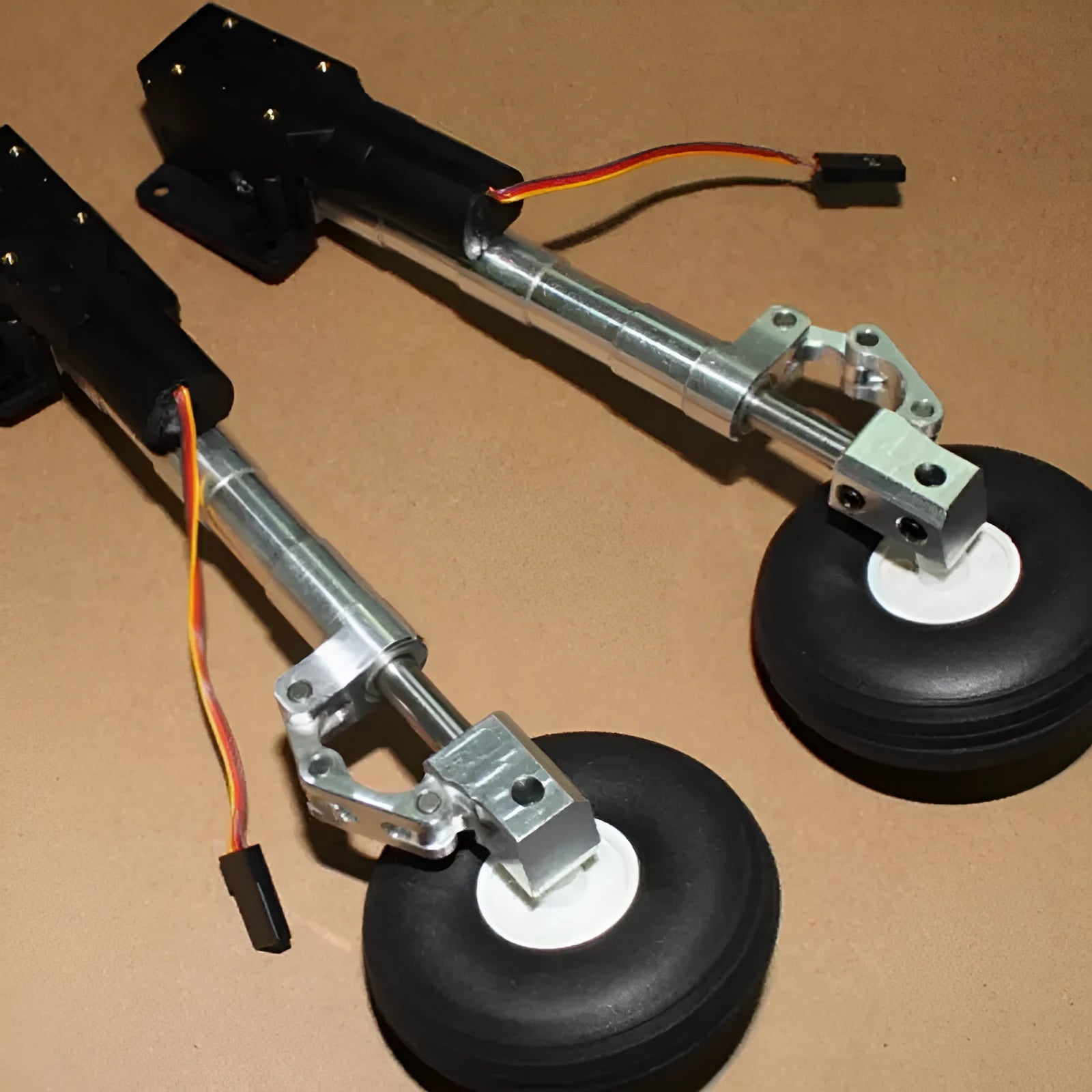 Alloy retractable shock-absorbing landing gear for model aircraft with wheel options.