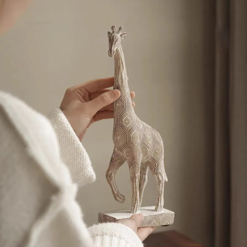 Tall wooden-coloured giraffe resin figurine ornament on a surface.