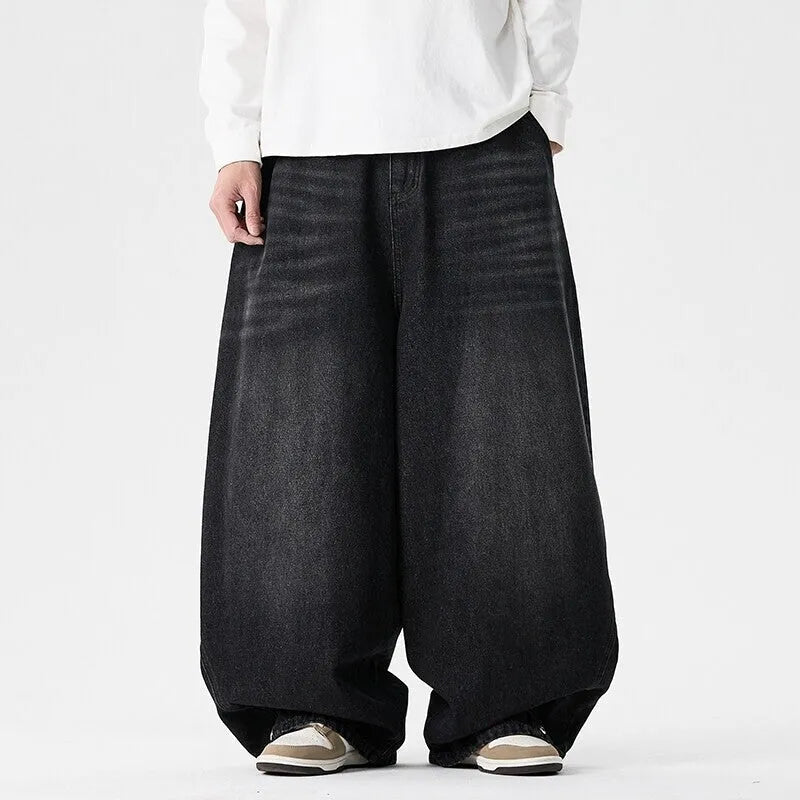 Men's plus size baggy blue denim jeans with a straight leg and low waist on a hanger.
