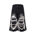 Woman wearing black distressed wide leg cropped jeans with ripped patches.
