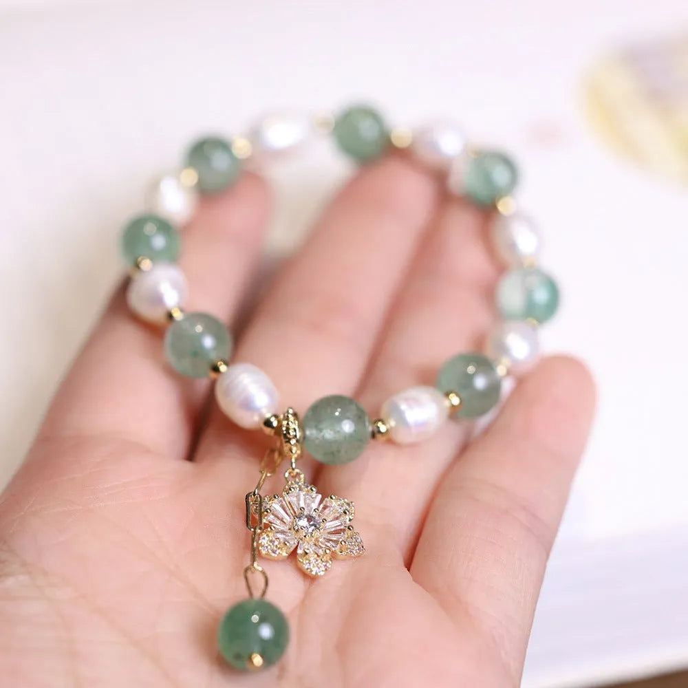 Green geometric strawberry freshwater pearl bracelet with small flower charm and Chinese knot design.