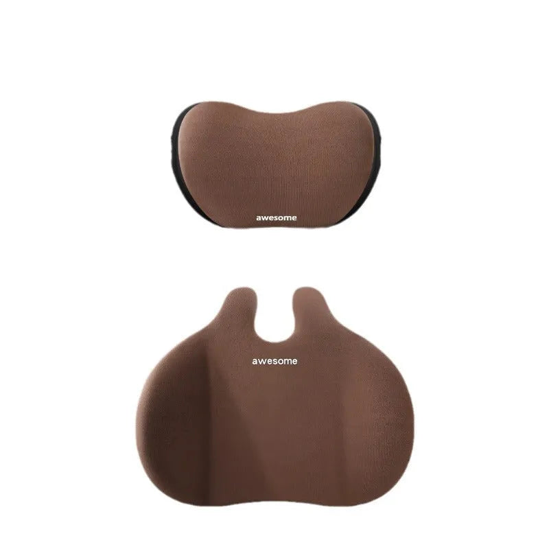 Cow head style black automotive headrest pillow and matching lumbar support pillow on a car seat.