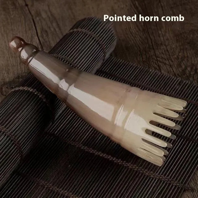 White buffalo horn massage comb with wide teeth and pointed tip for scalp acupressure.