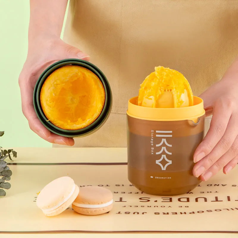 White manual citrus juicer with cup for squeezing lemons and oranges, showing three-part design