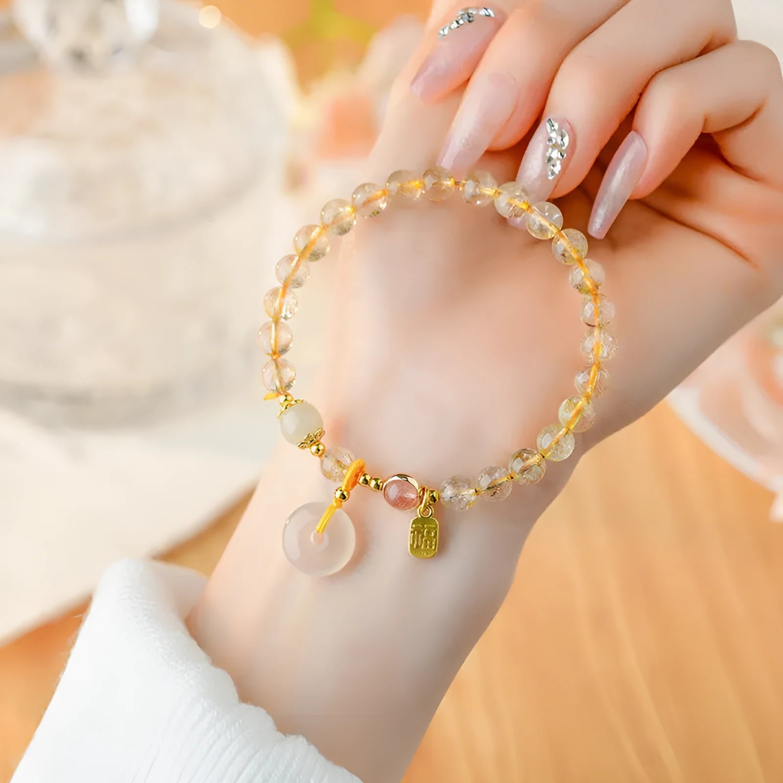 Gold rutilated quartz crystal bracelet with safety buckle and geometric national style design featuring blessing card pendant.