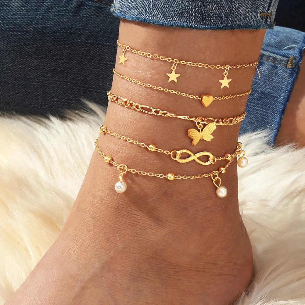 Four-piece women's alloy anklet set with butterfly and pearl heart charms in multi-layer design