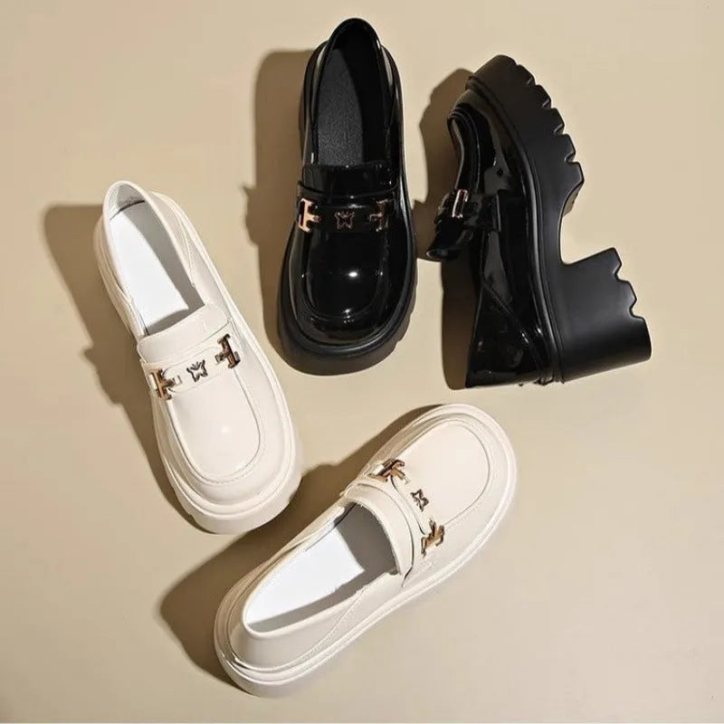 Black slip-on chunky heel shoes with a skull pattern on the front and a square rubber sole.