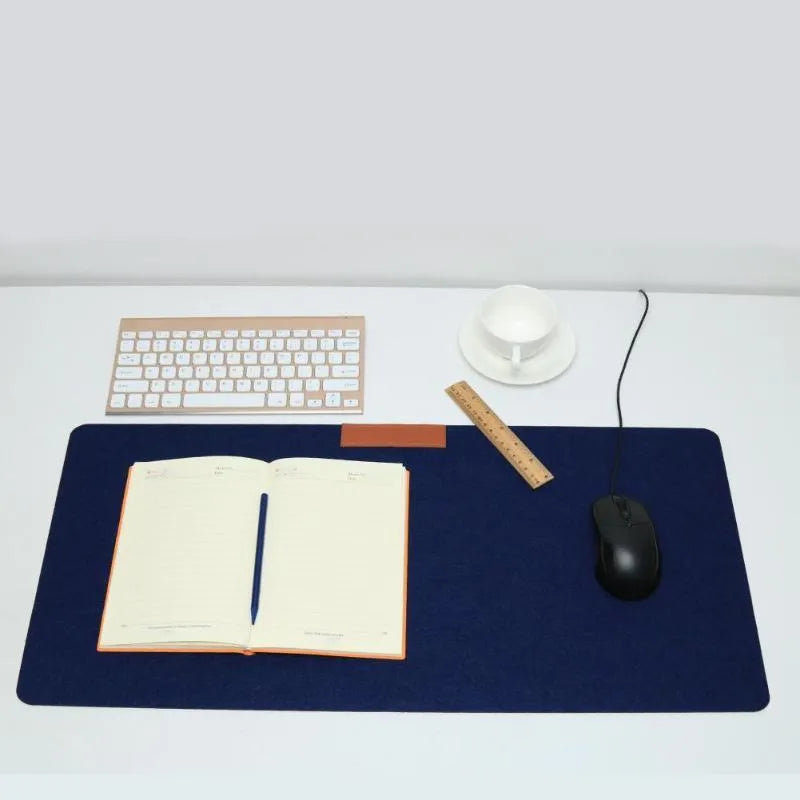 Large black felt desk mat with sewn edges, measuring 325x635mm, on an office desk with a keyboard and mouse.