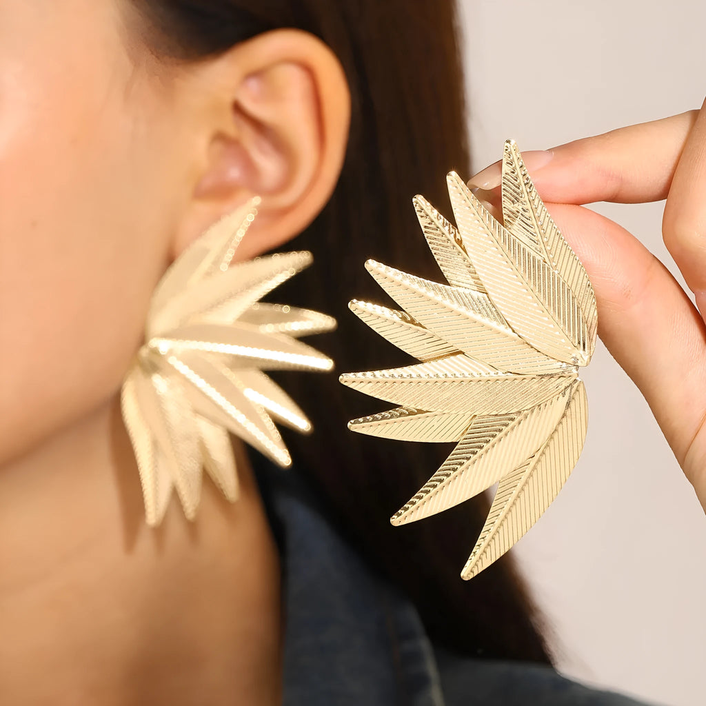 Gold and white leaf-shaped alloy patch earrings with botanical design details