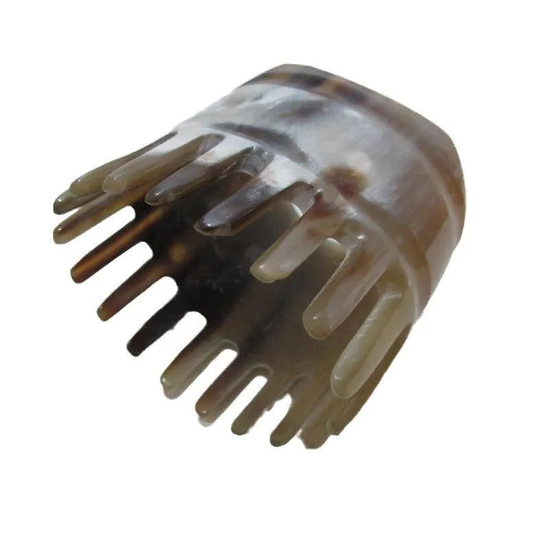 White buffalo horn massage comb with wide teeth and pointed tip for scalp acupressure.