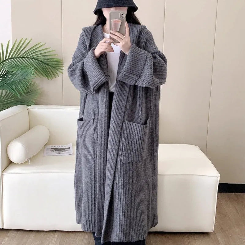 Loose grey hooded cardigan coat with long sleeves on a hanger