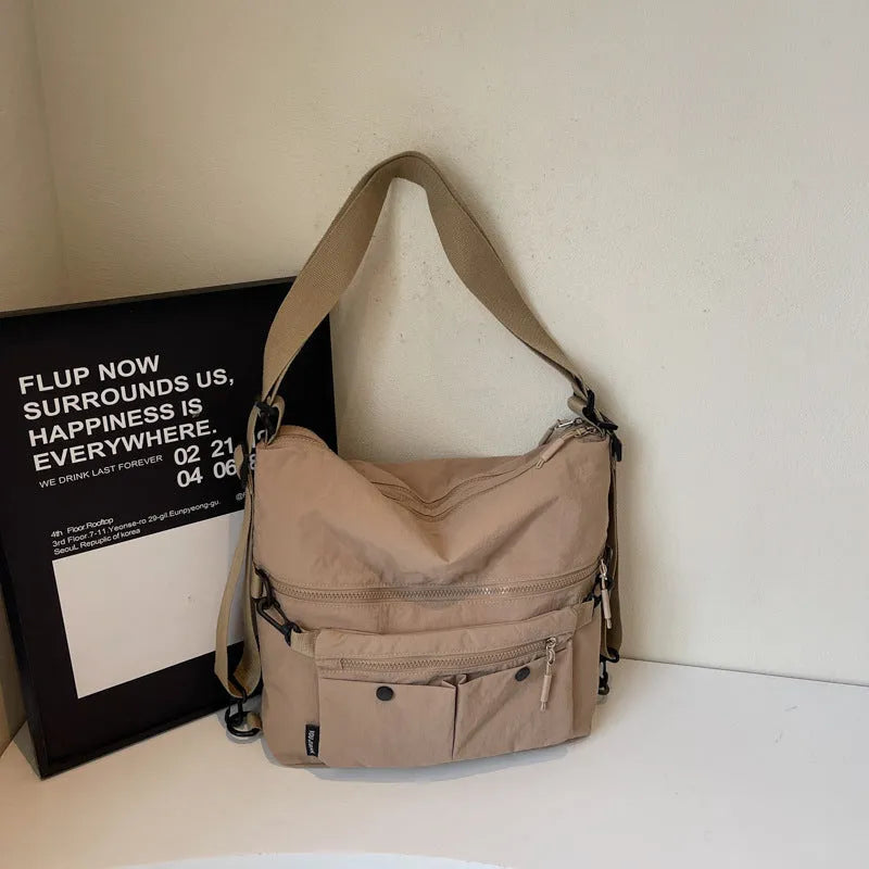 Women's nylon crossbody bag with double shoulder straps showing multiple pockets in black colour