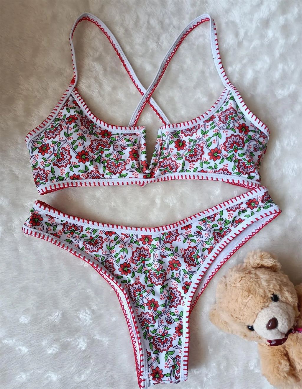 Women's one-piece swimsuit with V-neck embroidery and floral print on blue background.
