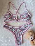 Women's one-piece swimsuit with V-neck embroidery and floral print on blue background.
