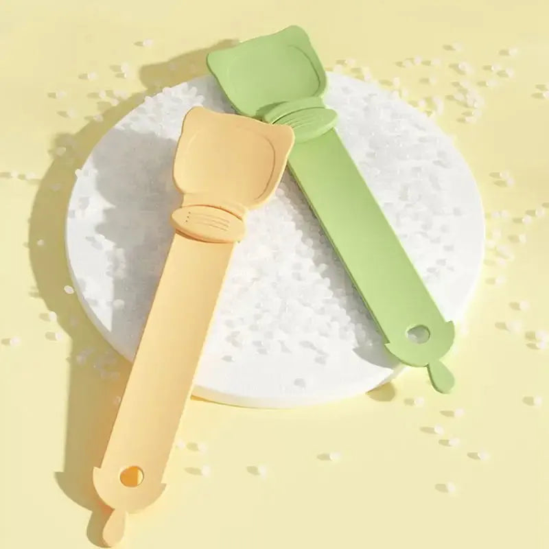 Cat strip feeder spoon in orange, green, and white, 27 x 6.5 cm reusable treat dispenser