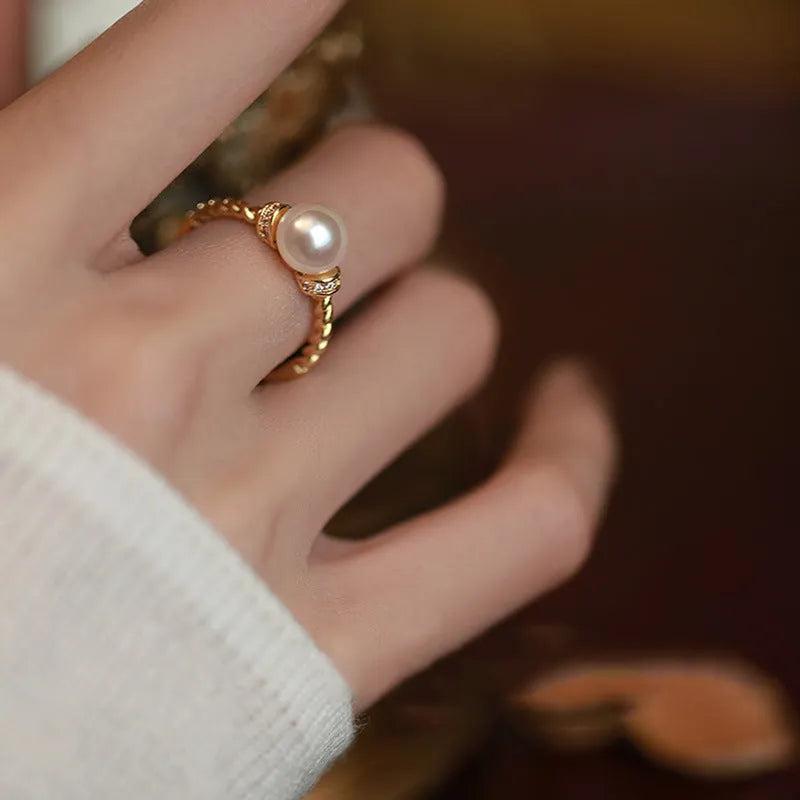 Adjustable antique twist copper ring with a geometric pearl centre in gold and silver colours.