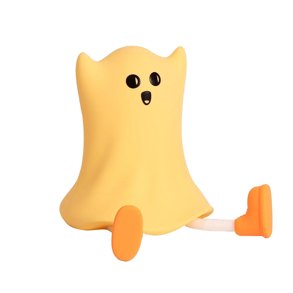 Cartoon ghost-shaped silicone bedside lamp with touch control, soft yellow glow on a bedside table