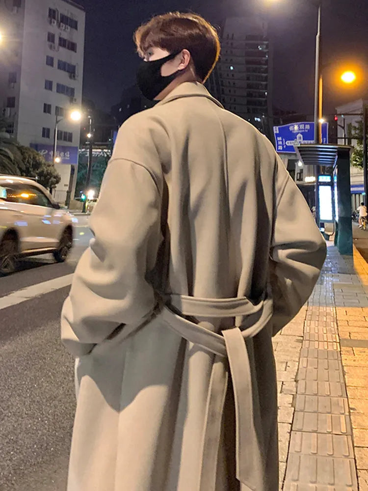 Men's British style mid-long wool coat in khaki with side seam pockets on a hanger