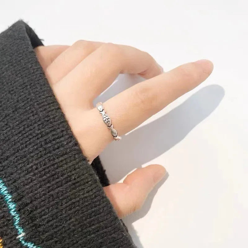 Women's sterling silver adjustable fish ring with carp motif on finger.