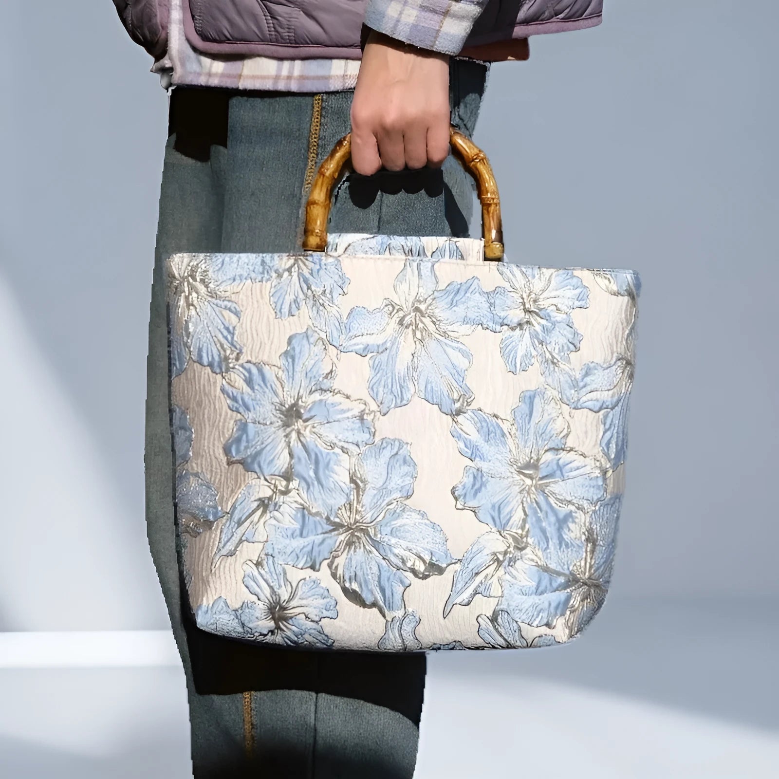 Light blue canvas shoulder bag with bronzing flower print, square shape, and two adjustable connector straps