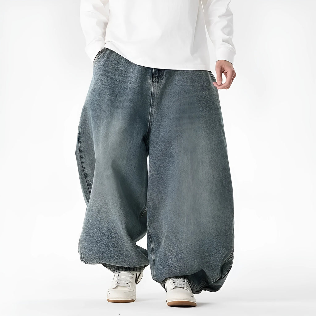 Men's plus size baggy blue denim jeans with a straight leg and low waist on a hanger.