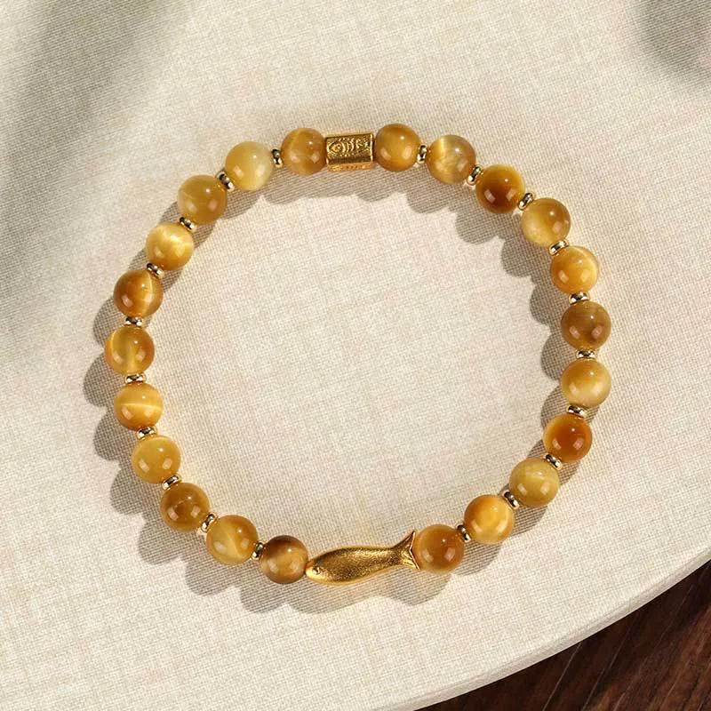 Handmade women's bracelet with tiger eye gemstone beads carved into small fish designs