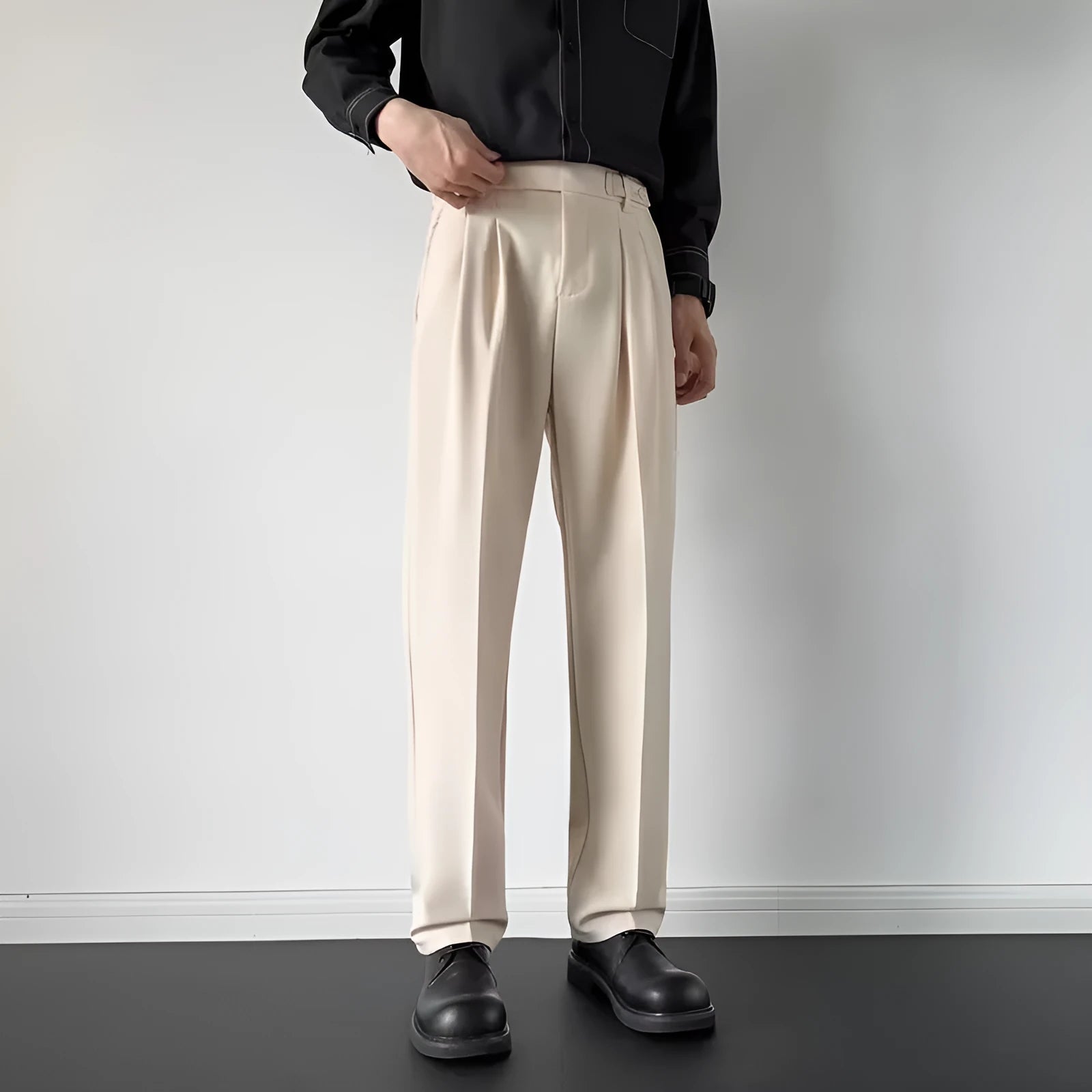 Man wearing straight-loose fit suit trousers in apricot colour, showcasing the leg cut and formal style.