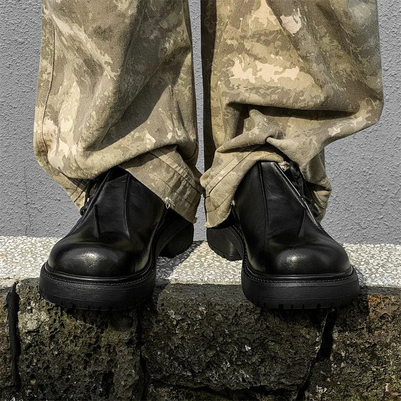Black leather-style platform shoes with a round toe and low-top design on a white background.