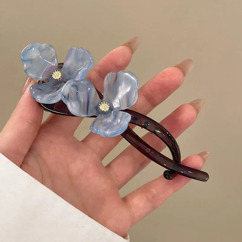 Retro flower petal bobby pin hair accessory in acrylic, shown on a background.