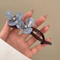 Retro flower petal bobby pin hair accessory in acrylic, shown on a background.