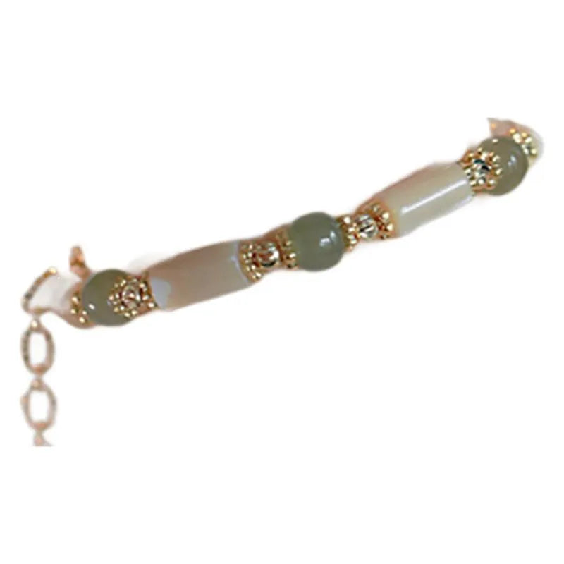 Simple women's bracelet made of round white Hetian jade beads on a wrist.