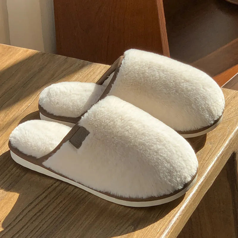 Blue plush PVC winter slipper with non-slip sole and car stitching detail on a wooden floor.
