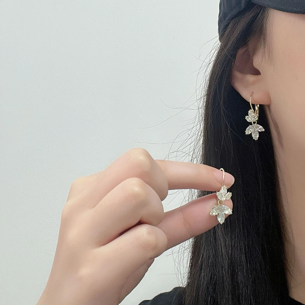 Platinum colour leaf-shaped drop earrings with shiny inlaid zircon details for women.
