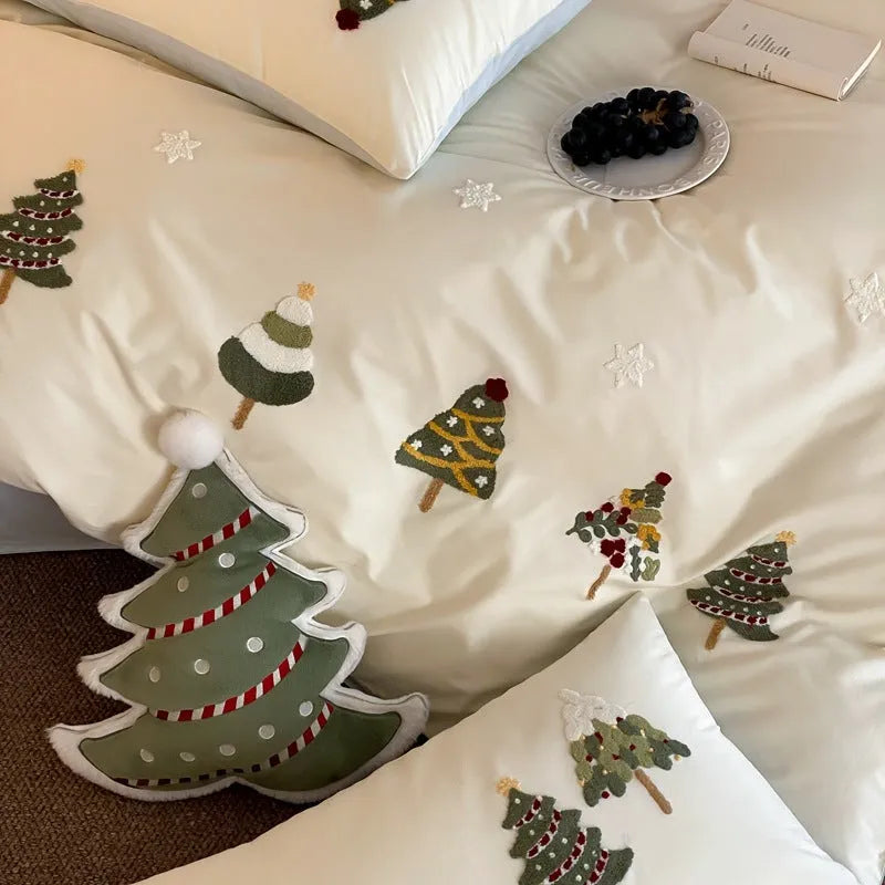 Pure cotton Christmas tree towel embroidery bedding four-piece set in cream blue on a bed.