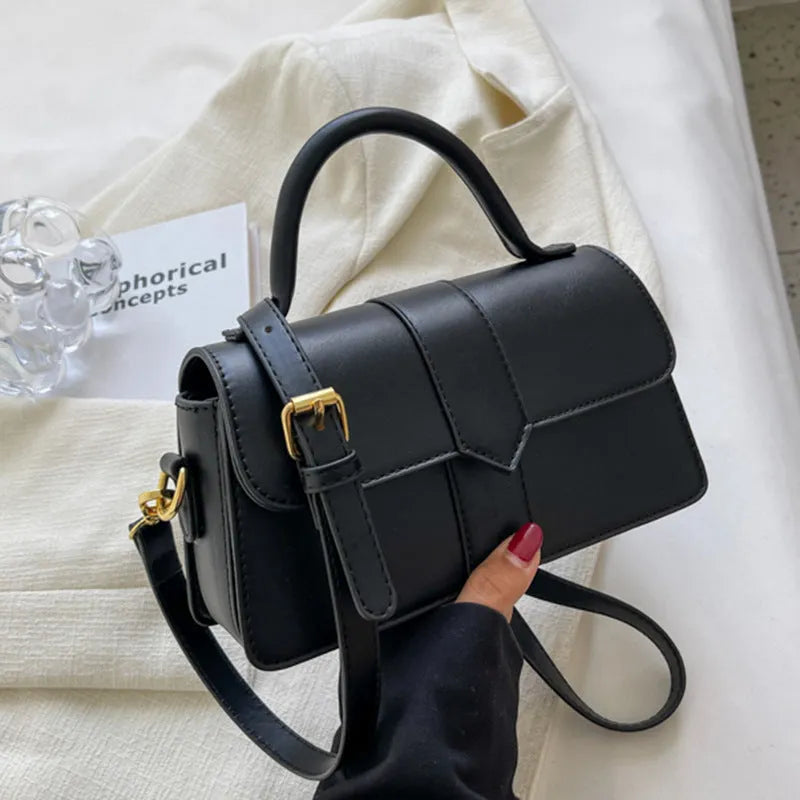 Beige women's square messenger bag with a top handle and shoulder strap, showing an outer pocket.