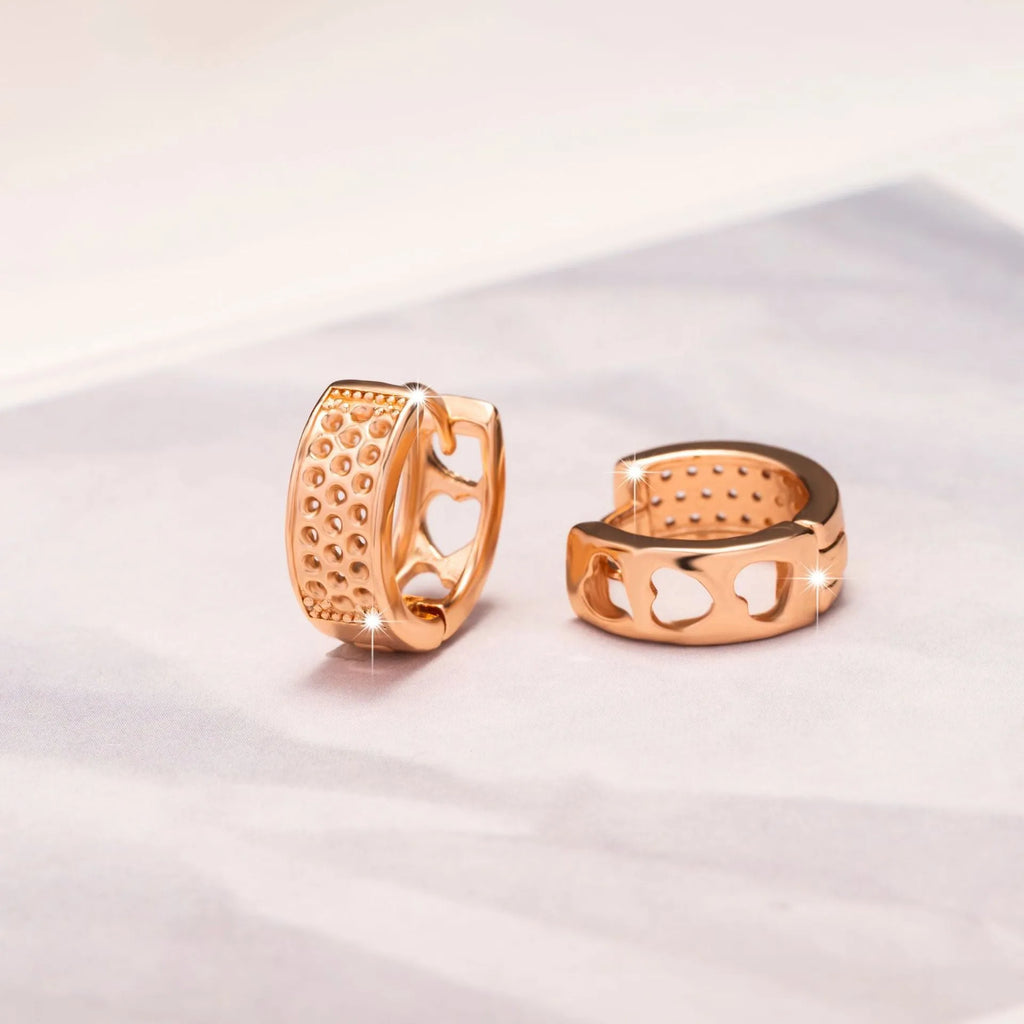 Rose gold hollowed-out stainless steel earrings showing three heart shapes in a circular design.