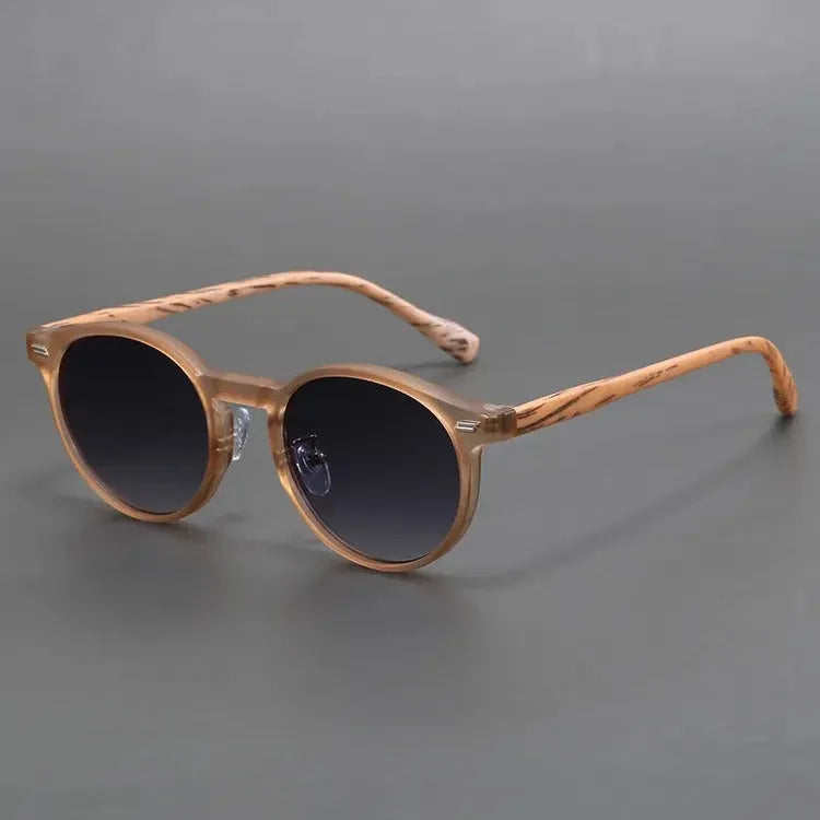 Retro round frosted sunglasses in leopard print and sand colours on a patterned background.