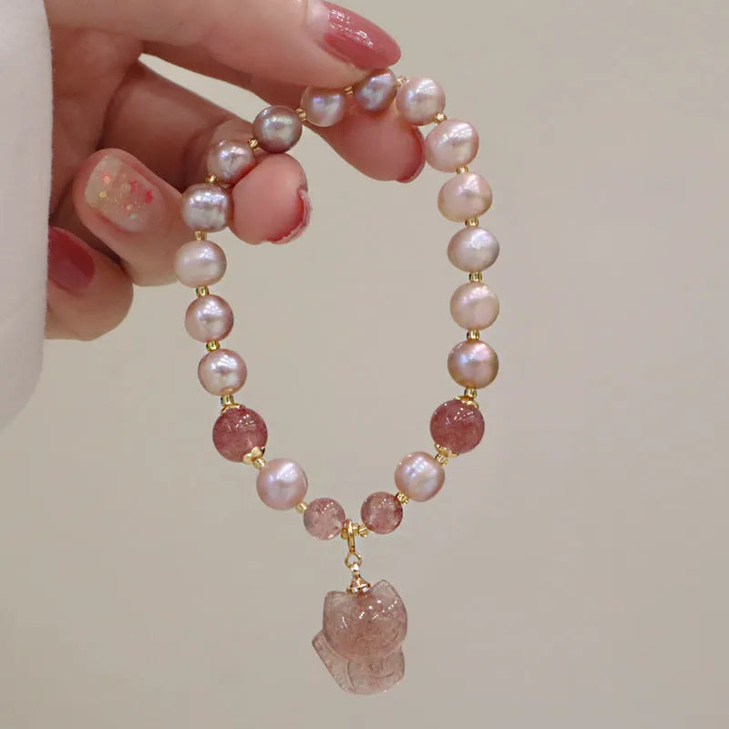 Light pink freshwater pearl bracelet with silver fox charm and strawberry quartz detail on adjustable strand