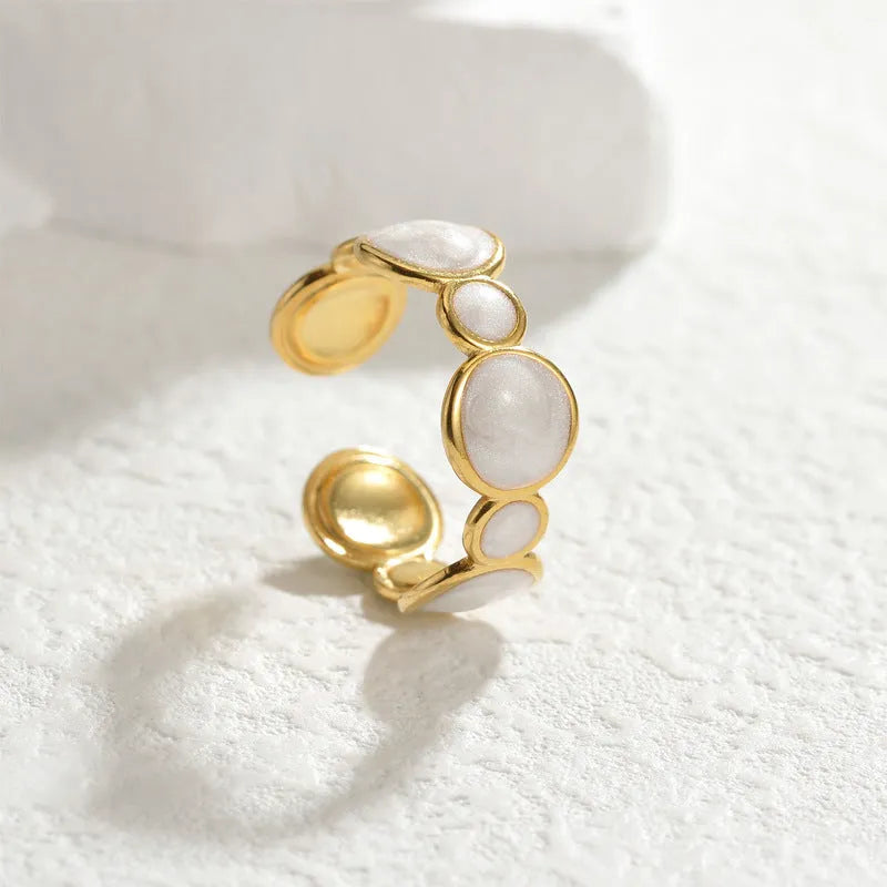 Silver geometric ring with an adjustable opening on a plain background
