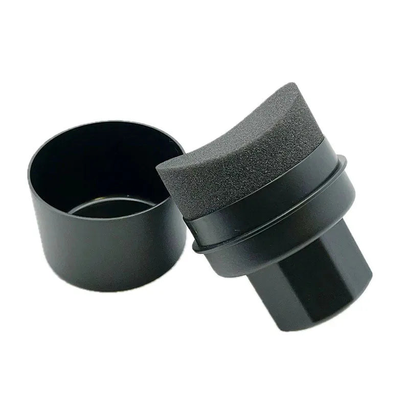 Black and red car tyre polishing sponge brushes with lids on a workbench.