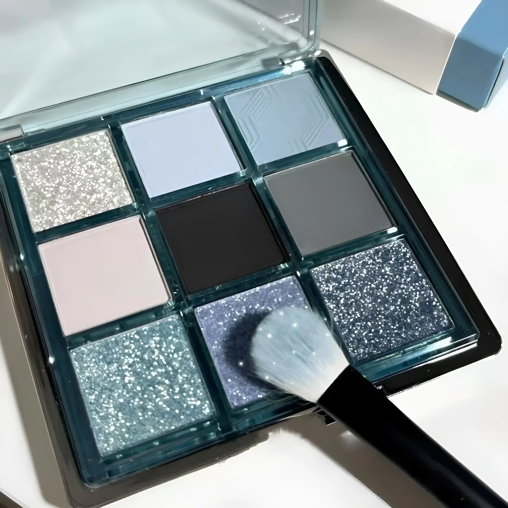 MUGELEEN nine-colour eyeshadow palette showing ice blue smoked shades and earth tone mattes